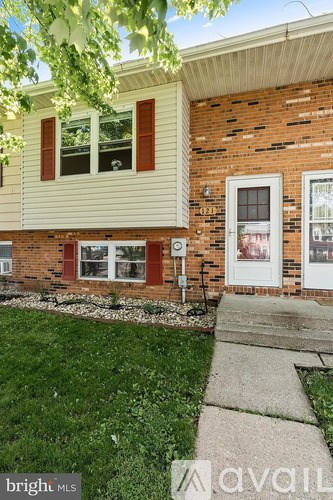 A house with a white door and a brick wall.