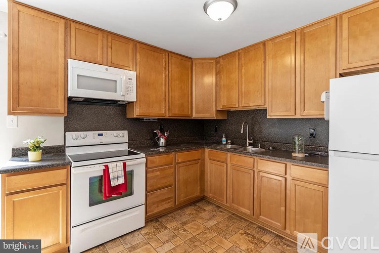 A kitchen with wooden cabinets and a white stove top oven.