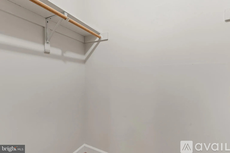 A white wall with a wooden beam and metal brackets.