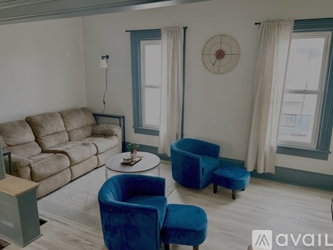 A living room with a blue chair and a beige couch.