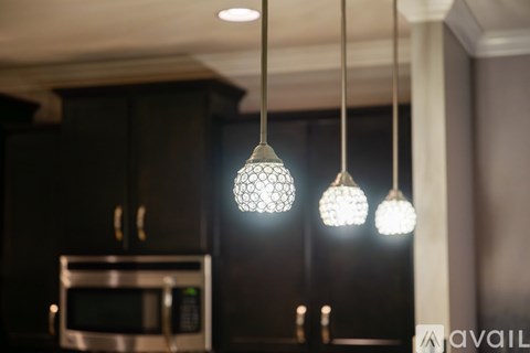Three pendant lights are hanging from the ceiling above a kitchen counter.