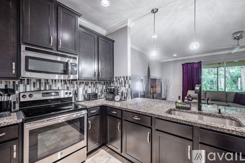 A kitchen with dark wood cabinets and granite countertops.