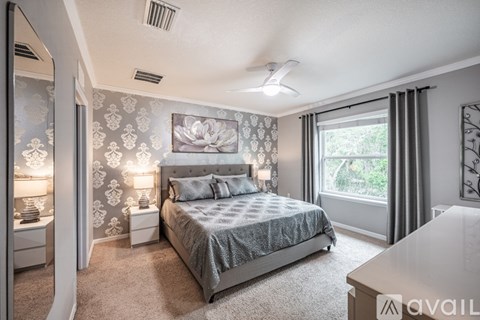 A bedroom with a large bed and a painting on the wall.