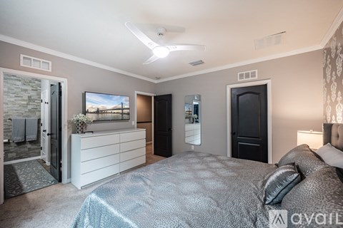 A bedroom with a bed, dresser, and television.