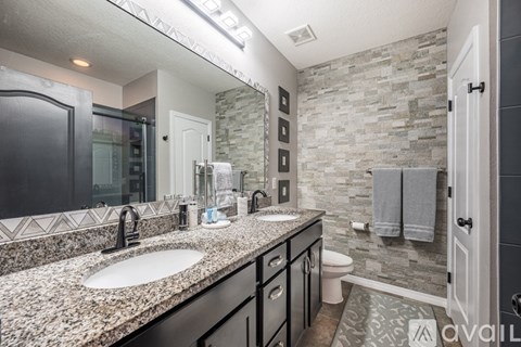 A bathroom with a stone wall and a sink.