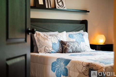 A bed with a blue and white comforter and two matching pillows.