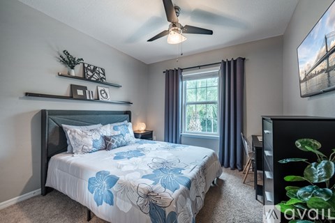 A bedroom with a large bed and a ceiling fan.