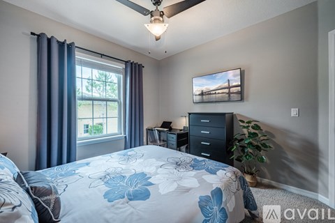 A bedroom with a bed, dresser, and a ceiling fan.