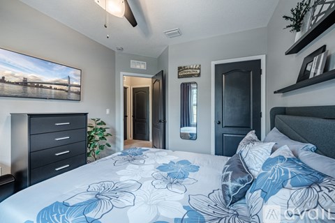 A bedroom with a bed, dresser, and a painting on the wall.