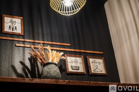 A wall with a sign that says "dry AWA" and a vase with dried plants.