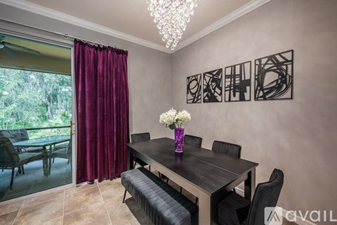 A dining room with a table and chairs and a chandelier.