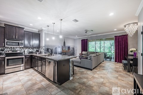 A modern kitchen with dark wood cabinets and stainless steel appliances.