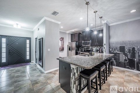 A modern kitchen with a large island and bar stools.