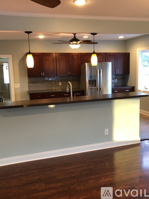 A kitchen with wooden cabinets and a dark countertop.
