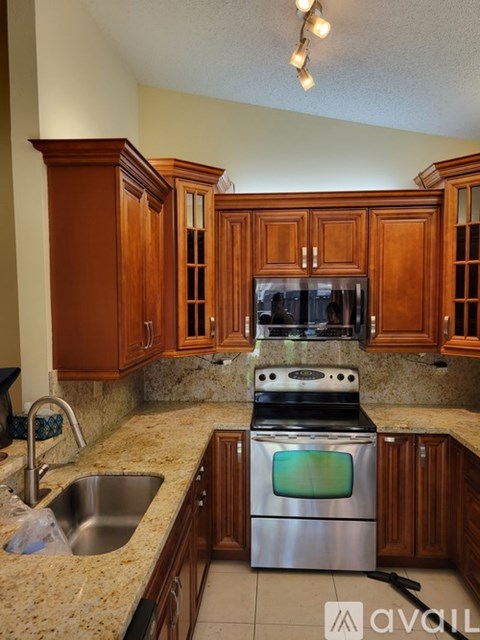 A kitchen with wooden cabinets and granite countertops.