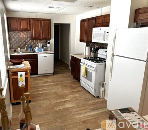 A kitchen with wooden cabinets and a white refrigerator.