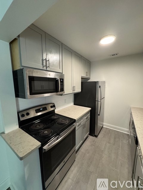 A kitchen with a black stove top oven and black microwave.