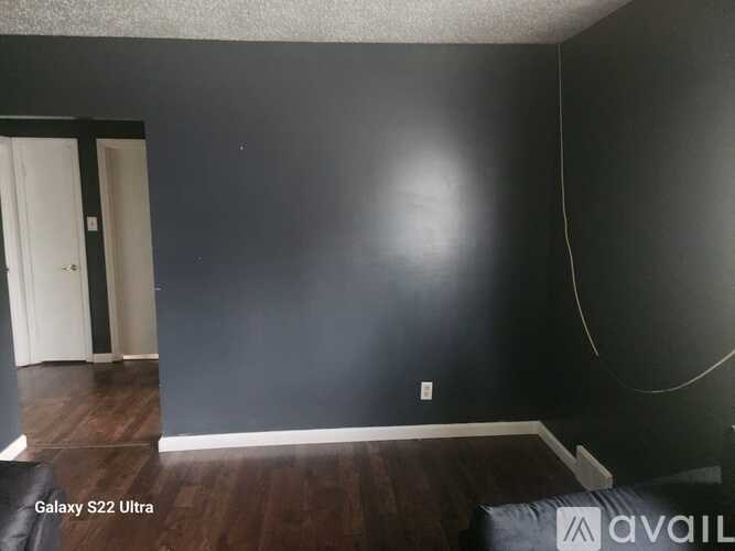 A room with dark walls and a wooden floor.