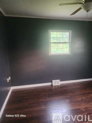 A room with a window and a ceiling fan.