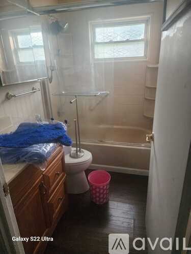 A bathroom with a toilet, a tub, and a window.