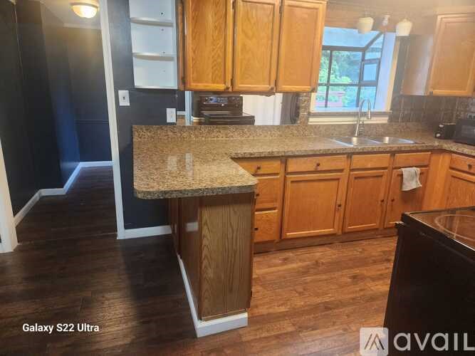 A kitchen with wooden cabinets and a granite countertop.
