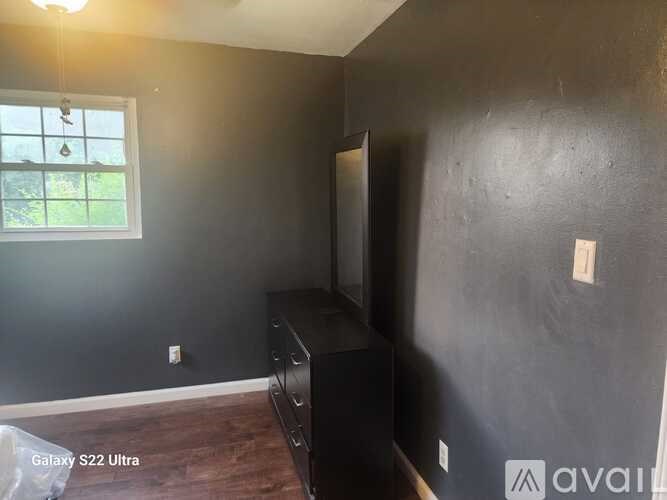 A room with a flat screen TV and wooden flooring.