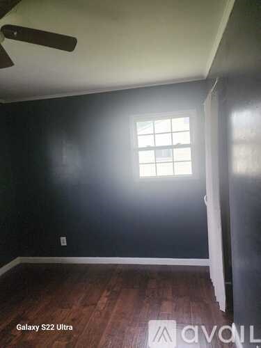 A room with a window and wooden floors.