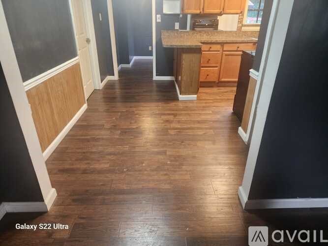 A kitchen with wooden floors and cabinets.