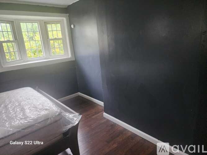 A room with a window and a bed covered in plastic.