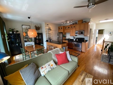 A living room with a couch and a kitchen in the background.