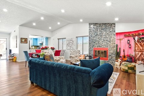 A living room with a blue couch and a wooden floor.