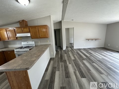 A kitchen with wooden cabinets and a countertop is available for rent.