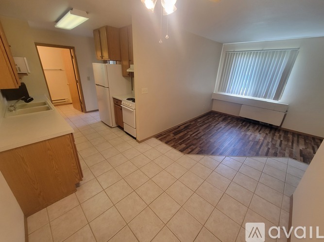A kitchen with white appliances and wooden cabinets.