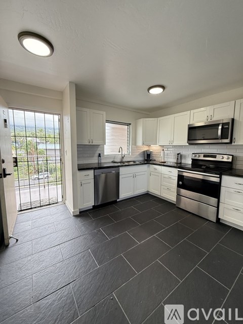 A kitchen with white cabinets and black appliances.