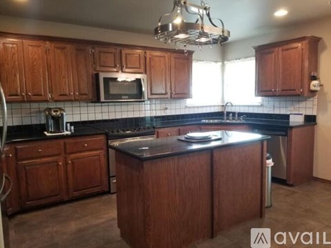 A kitchen with wooden cabinets and a black countertop.