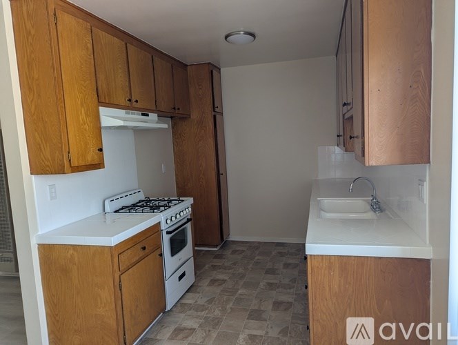 A kitchen with wooden cabinets and a white countertop.