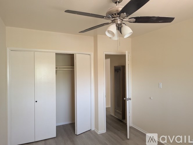 A room with a ceiling fan and a cabinet.