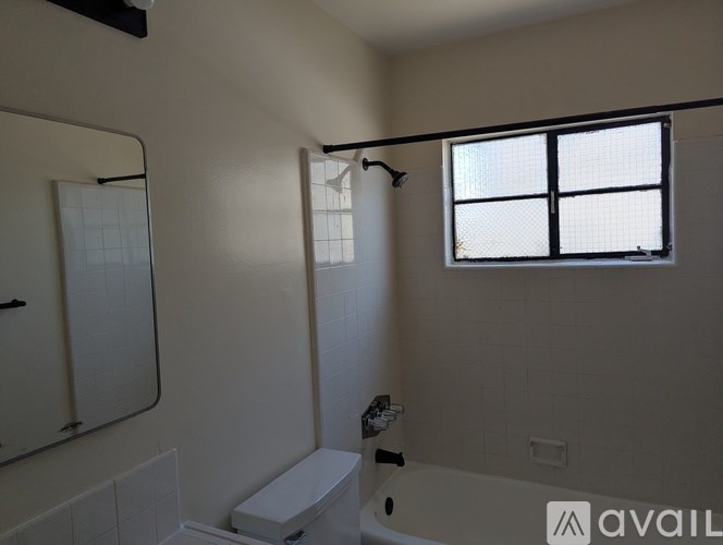 A bathroom with a toilet, sink, and window.