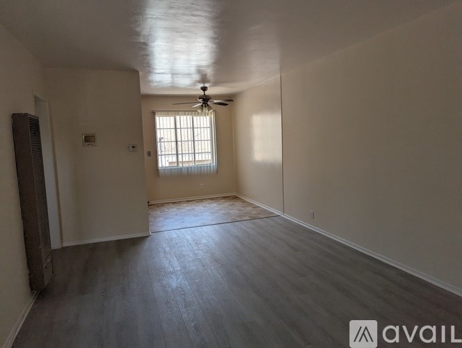 A room with a ceiling fan and a window.