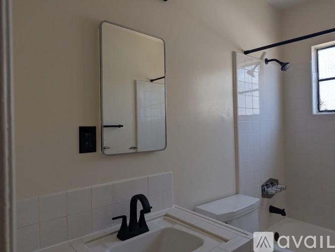 A bathroom with a sink, toilet, and mirror.