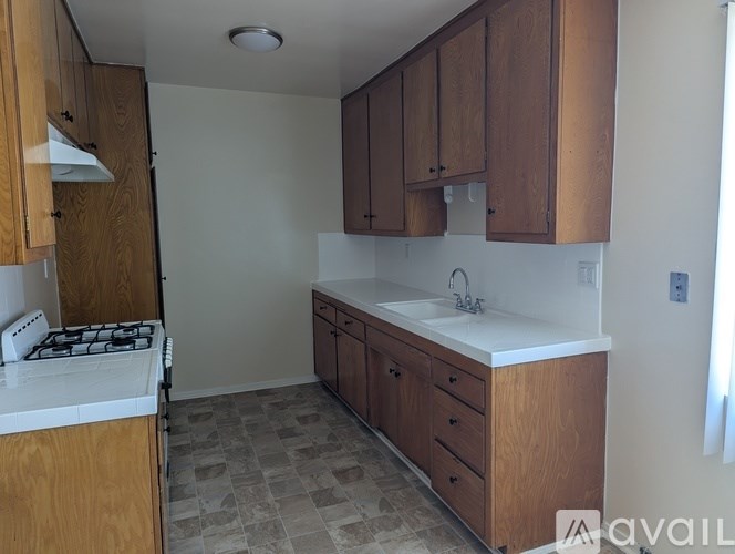 A kitchen with wooden cabinets and a white stove top.