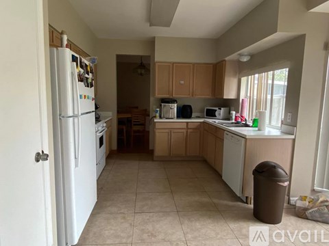 A kitchen with a white refrigerator and brown cabinets.