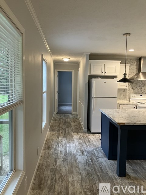 A kitchen with a white fridge and a dark counter top.