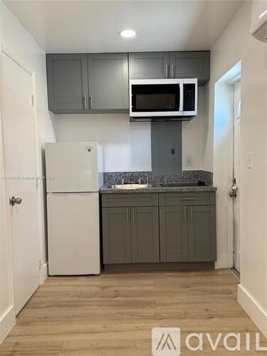 A kitchen with a white refrigerator and a microwave above the counter.