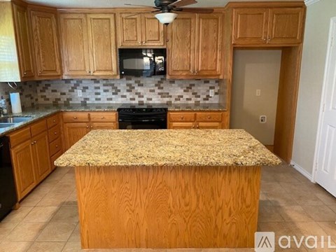 A kitchen with wooden cabinets and a granite countertop.