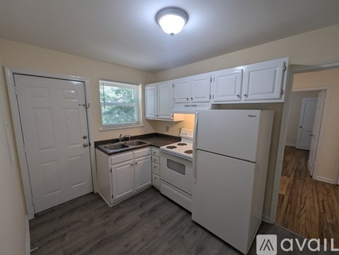A kitchen with white cabinets and appliances is available for rent.