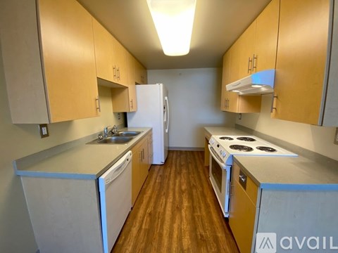 A kitchen with wooden cabinets and a white fridge.