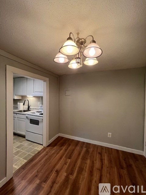 A kitchen with a white oven and wooden floors.