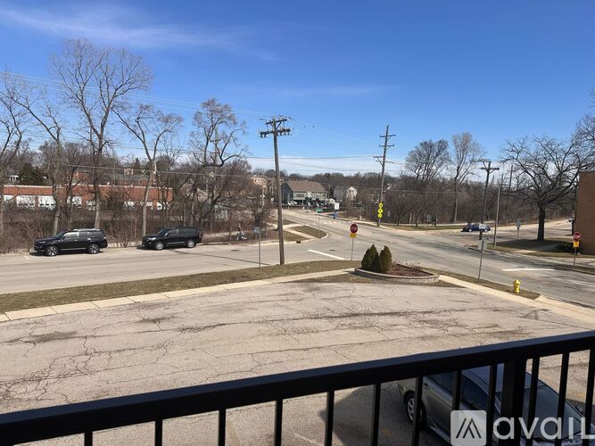 A parking lot with cars and a yellow sign in the distance.