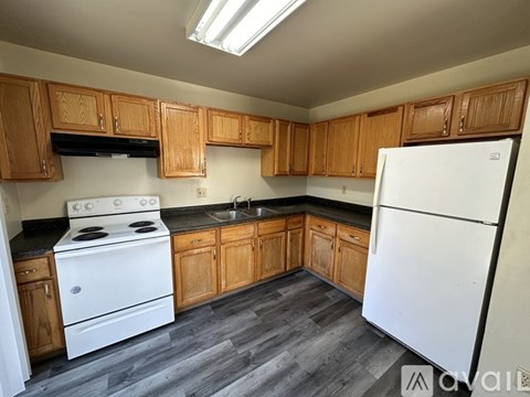 A kitchen with wooden cabinets and a white refrigerator.